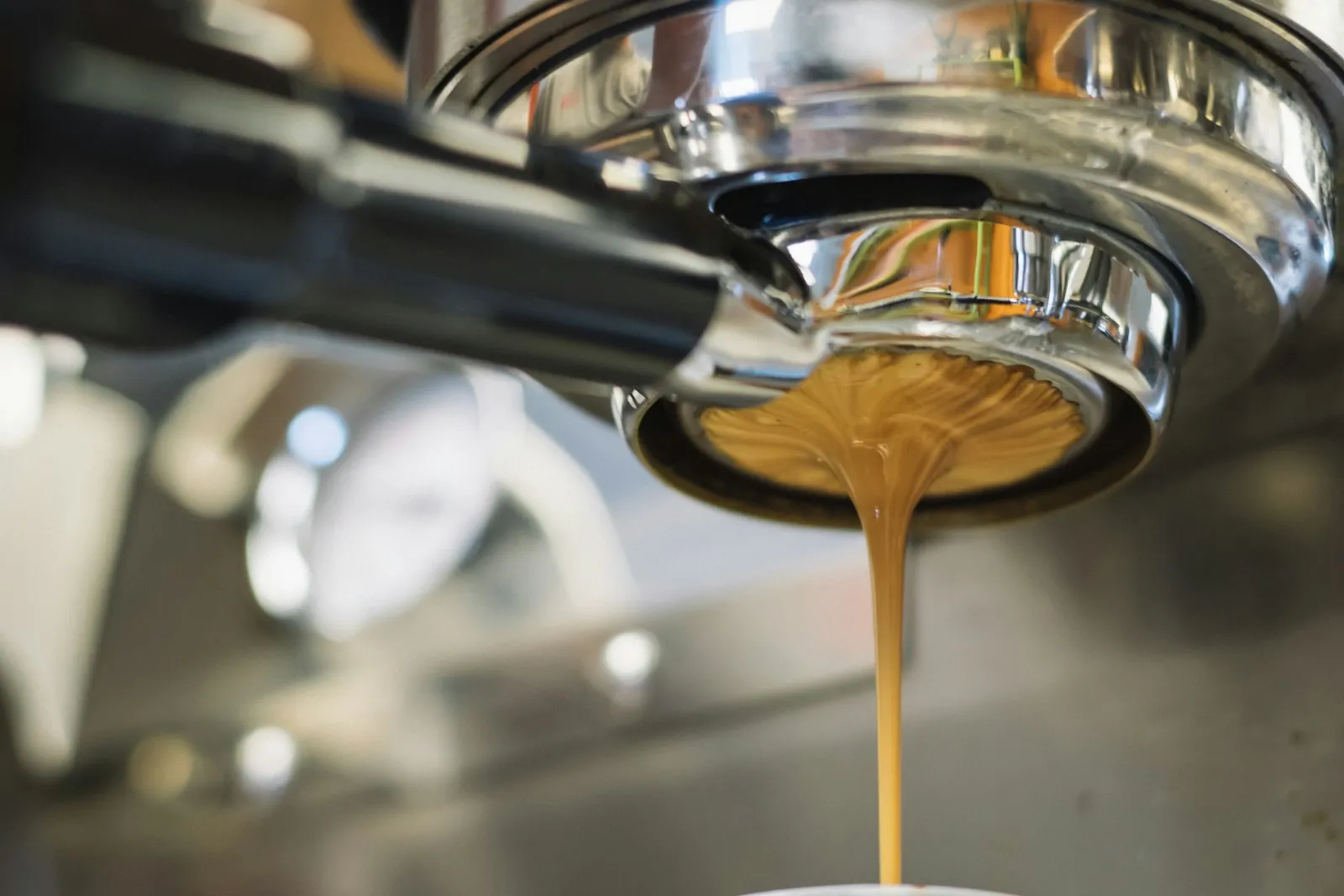 Verse espresso stroomt uit de zetgroep van een espressomachine